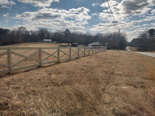 large yard with long wooden railing fence