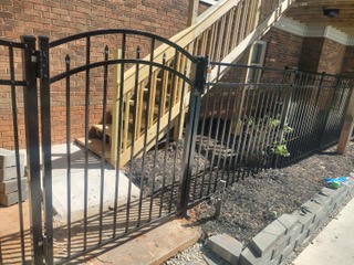 black iron fence surrounding home with large staircase