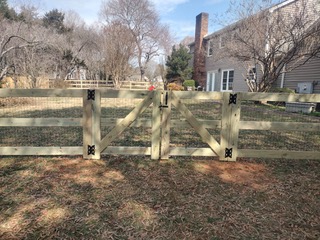 brown house with large wooden gated fence