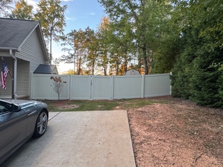 house with white fence and car in driveway